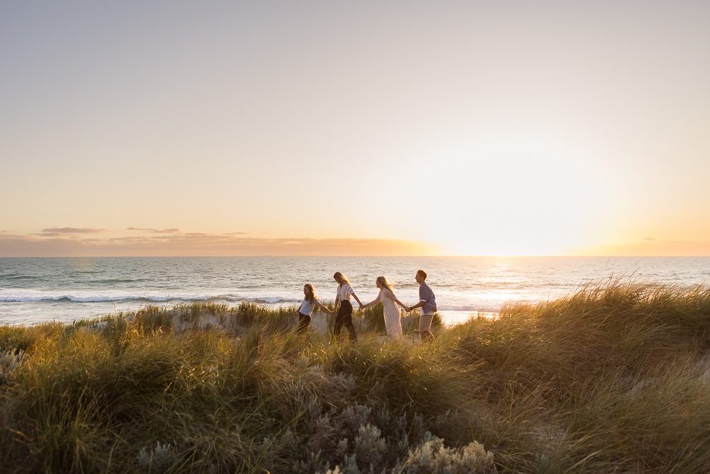 Family walking across the beach dunes