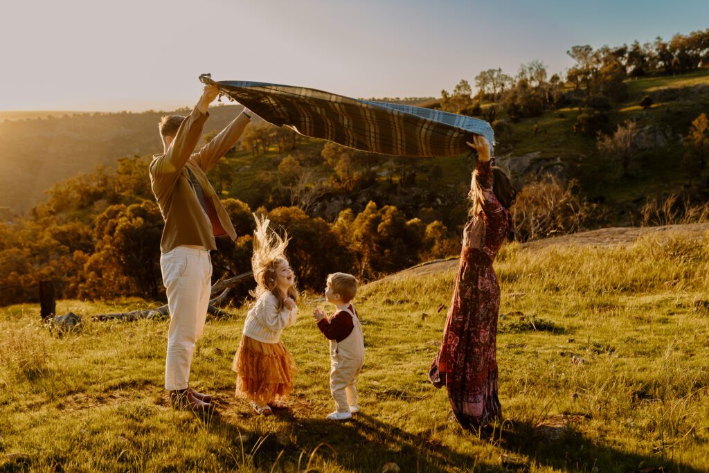 Children playing during a candid family photoshoot with relaxed parents in Perth Hills