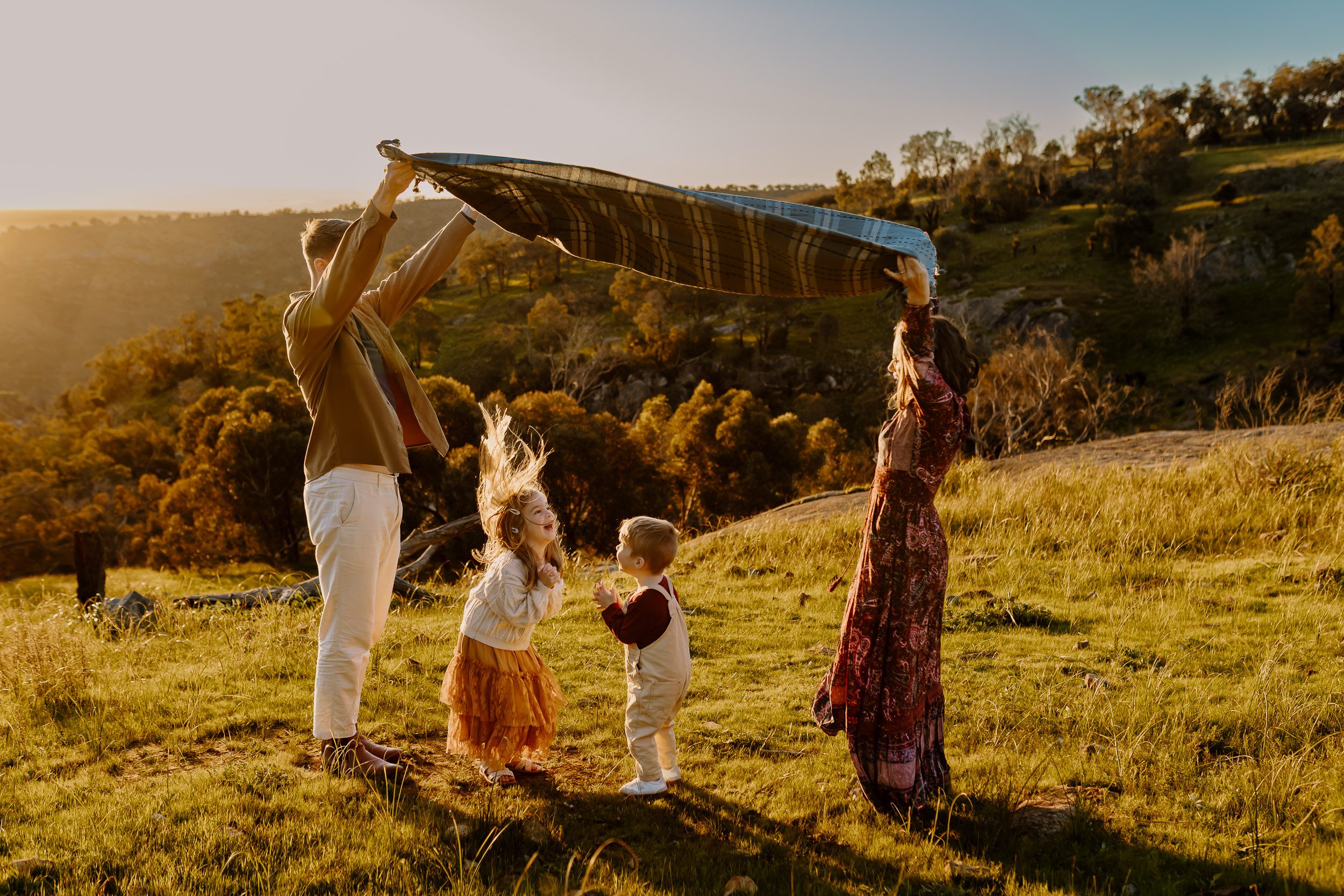 Children playing during a candid family photoshoot with relaxed parents in Perth Hills